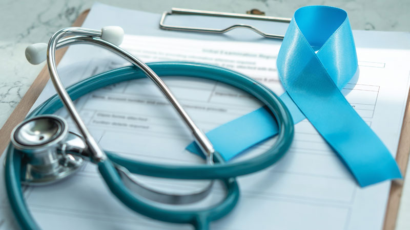 Folha de registo clínico com estetoscópio e laço azul em cima em representação dos rastreios oncológicos 